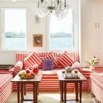 Indoor lounge area with red-and-white striped sofas and views of the Nile.