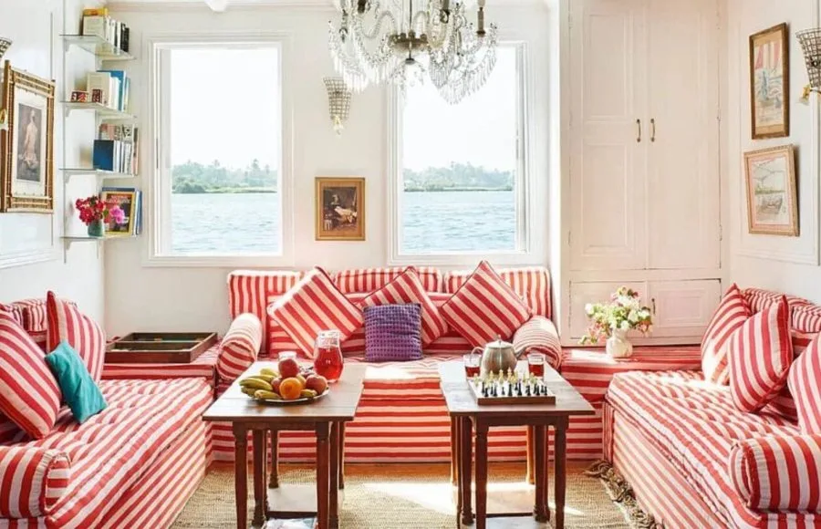 Indoor lounge area with red-and-white striped sofas and views of the Nile.