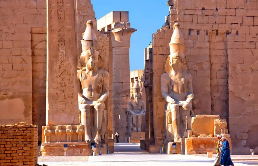A close-up view of the giant statues and columns at the entrance of the Luxor Temple, showcasing ancient Egyptian art and architecture.