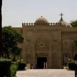 Outside view of the Coptic Museum in Cairo with its distinctive stone facade and cross-topped dome.