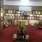 Interior view of the Egypt Papyrus Institute gallery showcasing framed papyrus paintings and statues.