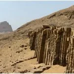 Side view of the Meidum Pyramid and ancient stone ruins in Egypt.