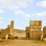 The Western Gate (Door of Sheshanq III) ruins at Tanis featuring large stone blocks and a colossal statue fragment.