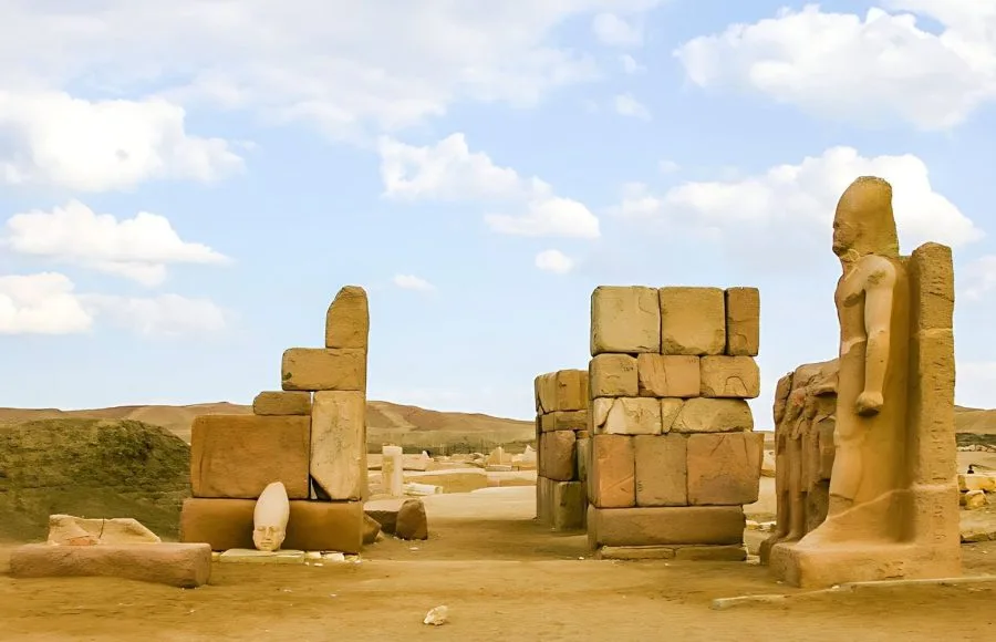 The Western Gate (Door of Sheshanq III) ruins at Tanis featuring large stone blocks and a colossal statue fragment.
