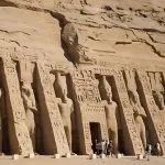 The impressive facade of the Temple Of Queen Nefertari Abu Simbel Egypt, featuring carved colossal statues of Nefertari and Ramses II, built into the sandstone cliff.