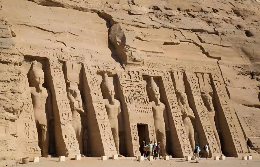 The impressive facade of the Temple Of Queen Nefertari Abu Simbel Egypt, featuring carved colossal statues of Nefertari and Ramses II, built into the sandstone cliff.