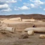 Broken, colossal stone ruins and inscribed blocks scatter the desert landscape at the ancient Egyptian site of Tanis (San el-Hagar).