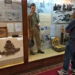 A tourist observes a World War II soldier mannequin and display of British artillery insignia and shells inside the El Alamein Military Museum.