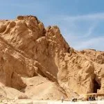 The rocky, mountainous cliff face of the Valley of the Queens Luxor egypt, showing the entrance area to the tombs below the rough desert rock.