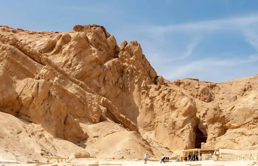 The rocky, mountainous cliff face of the Valley of the Queens Luxor egypt, showing the entrance area to the tombs below the rough desert rock.