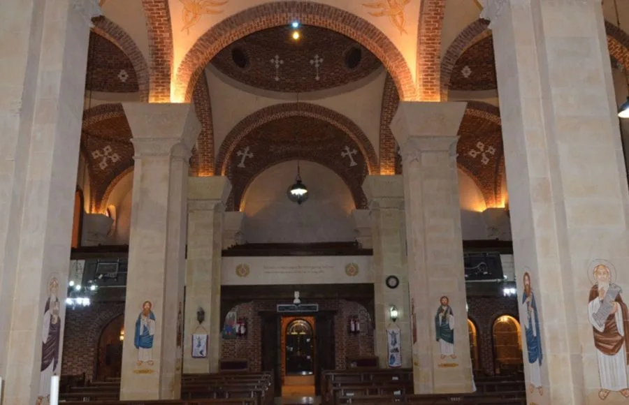 Interior of the Virgin Mary Church in Sakha, featuring arches, columns, and Coptic icons.