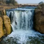 Water cascading over a small natural waterfall into a pool in Wadi Al Rayan, Fayoum.