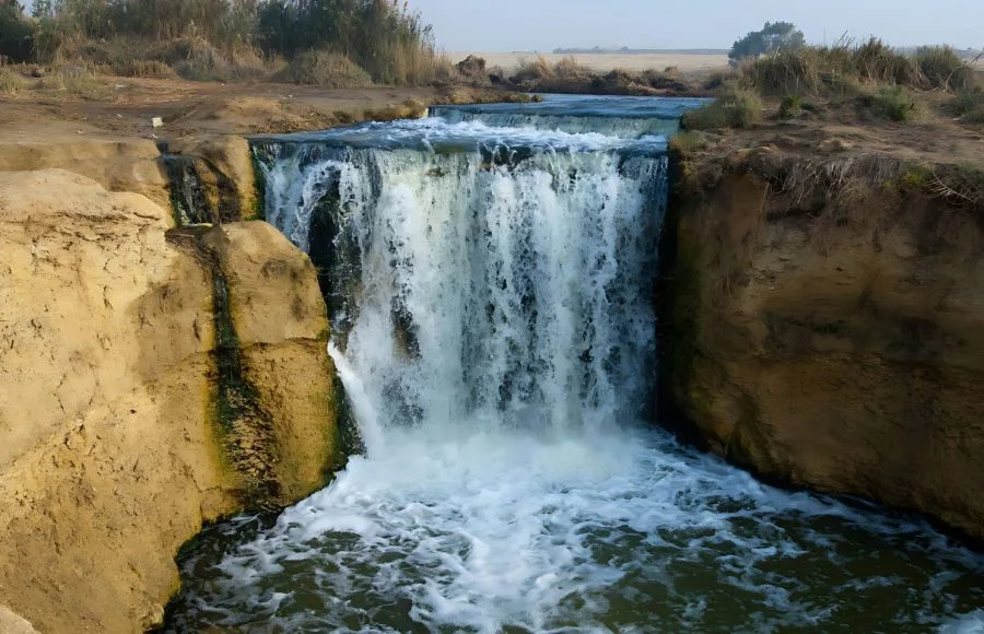 Water cascading over a small natural waterfall into a pool in Wadi Al Rayan, Fayoum.