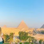 Tourist looking out at the three Great Pyramids of Giza.