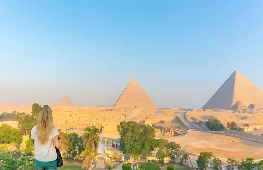 Tourist looking out at the three Great Pyramids of Giza.