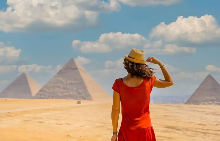 A-young-tourist-in-a-red-dress-looking-at-the-Pyramids-of-Giza