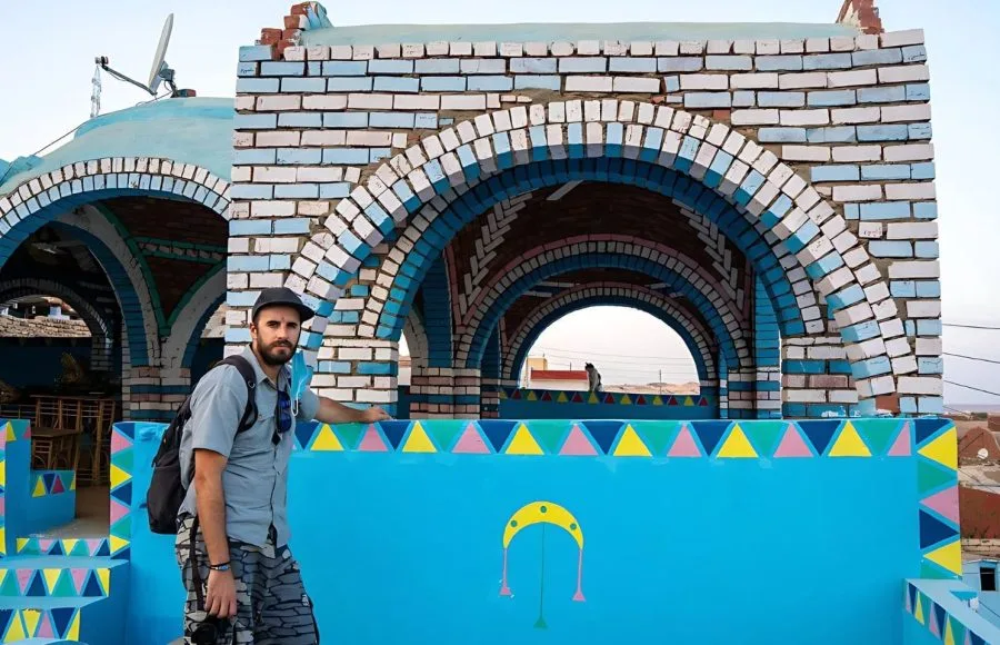 A-young-tourist-sitting-on-a-beautiful-terrace-of-a-traditional-blue-house-in-a-Nubian village