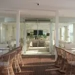 A stylish, modern lounge and bar area on the deck of a luxury yacht with views of the Nile River through large glass panels.