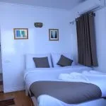 Interior view of a cozy, air-conditioned cabin on a traditional Egyptian Dahabiya sailboat with a bed and a view of the Nile River through a large window.
