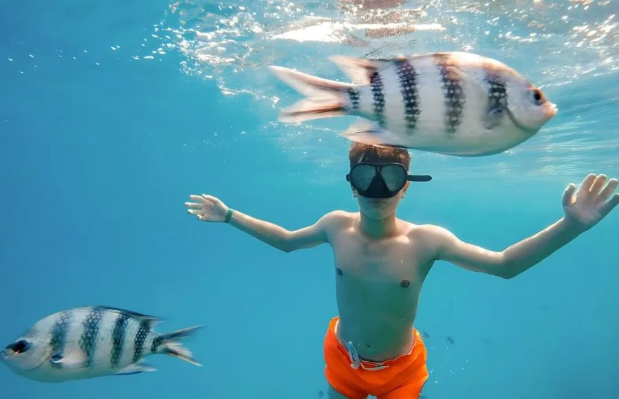 Young-boy-snorkel-swim-in-underwater-with-fish-Marsa-alam