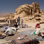 Bedouin-Desert-Camp-Tourists-Sat-On-Rugs-Eating-Flat-Bread