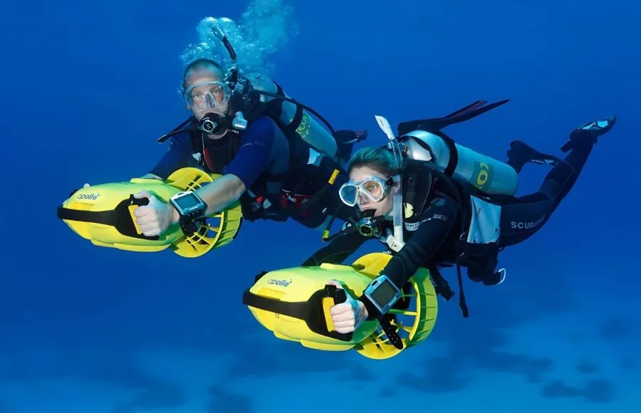 Divers-With-Diver-Propulsion-Vehicles-Exploring-A-Coral-Reef-Soma-Bay