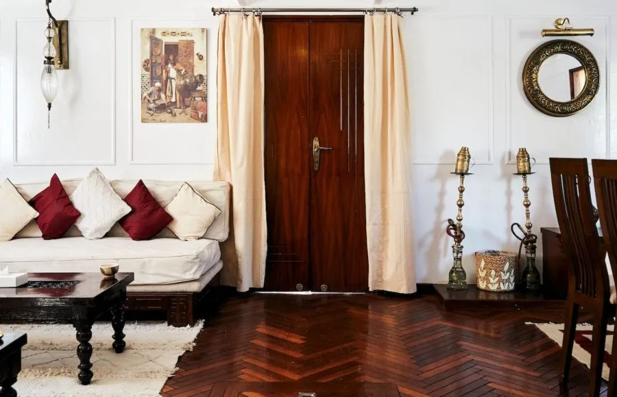 Lounge area with a couch, coffee table, and dark wood paneling on the Lazuli Albatros Dahabiya Nile Cruise