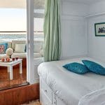 A view inside a cabin on the Lazuli Gordon Pacha Dahabiya Nile Cruise with a bed and a view outside.