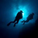Silhouette-Of-Two-Divers-In-Soma-Bay-Against-The-Sun