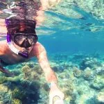 Underwater-in-the-tropics-paradise-with-snorkeling-man-fish-and-coral-reef-Safaga