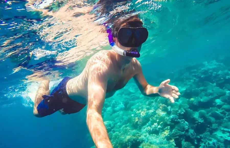 Underwater-with-snorkeling-man-fish-and-coral-reef-Safaga