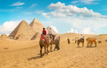 Tourists riding camels near the Pyramids of Giza a thrilling start to the 3 Day Cairo Luxor & Abu Simbel Short Break Tour