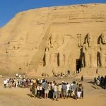 Large group of tourists gathering in front of the massive Abu Simbel Temple a major stop on Upper Egypt Tours