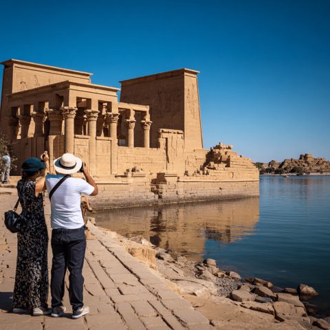 Tourists taking photos of Philae Temple in Aswan during one of our 4-day Egypt tour packages.