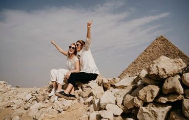 Two happy tourists at the Giza Pyramids, part of a Cairo and Nile Cruise 6 Days itinerary.