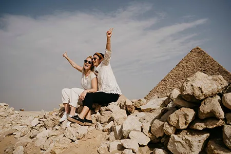 Two happy tourists at the Giza Pyramids, part of a Cairo and Nile Cruise 6 Days itinerary.