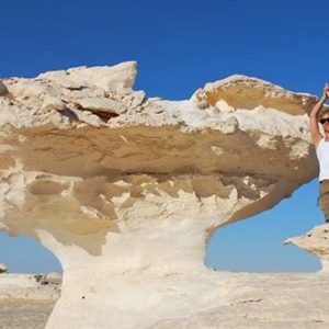 A Female Traveler Doing A Yoga Tree Pose Next To A Unique White Chalk Rock Formation In The White Desert During A 9 Day Highlights Of Egypt Adventure Tour