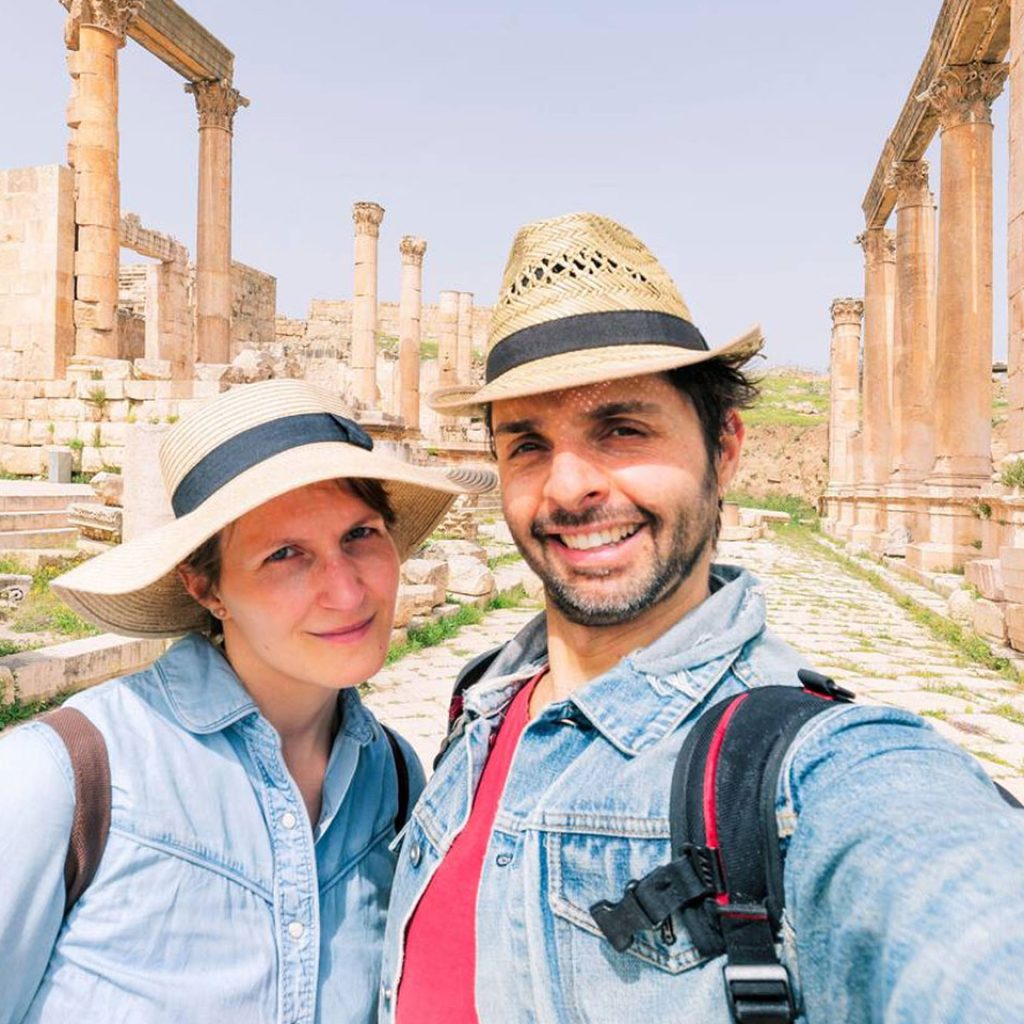 A Couple Taking A Selfie Photo In Front Of The Roman Ruin Of Jerash In Jordan