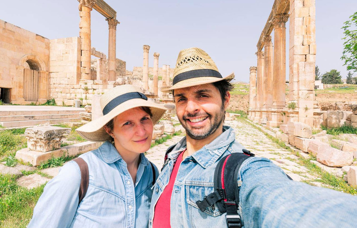 A Couple Taking A Selfie Photo In Front Of The Roman Ruin Of Jerash In Jordan