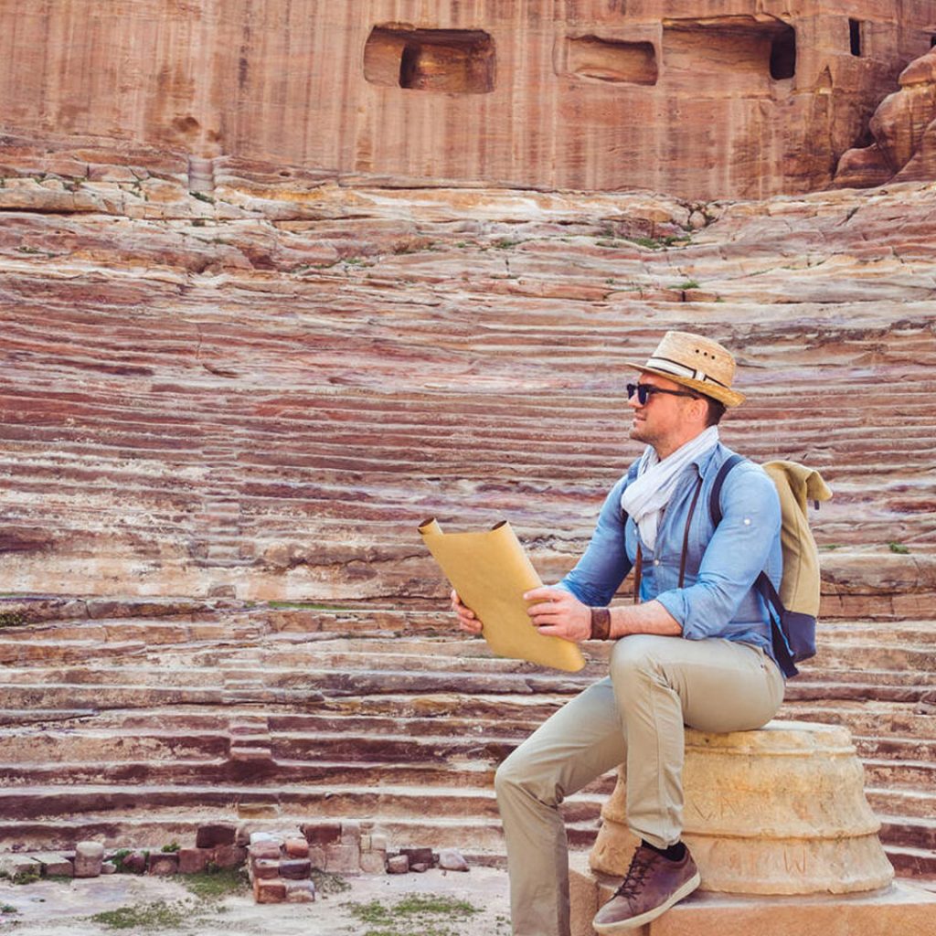 A Fashionable Tourist Exploring The Sights Of The Ancient Fabulous City Of Petra In Jordan