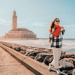 A-Young-woman-walking-on-the-breakwater-near-Hassan-II-Mosque-in-Casablanca-Morocco-during-a-sunny-day