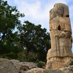A-closeup-of-a-stone-statue-against-a-blue-sky-in-the-historic-Arsameia-Turkey