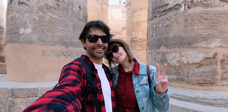 A Couple In Love Takes A Selfie Photo Among The Giant Columns In The Karnak Temple In Luxor During The Honeymoon Tour