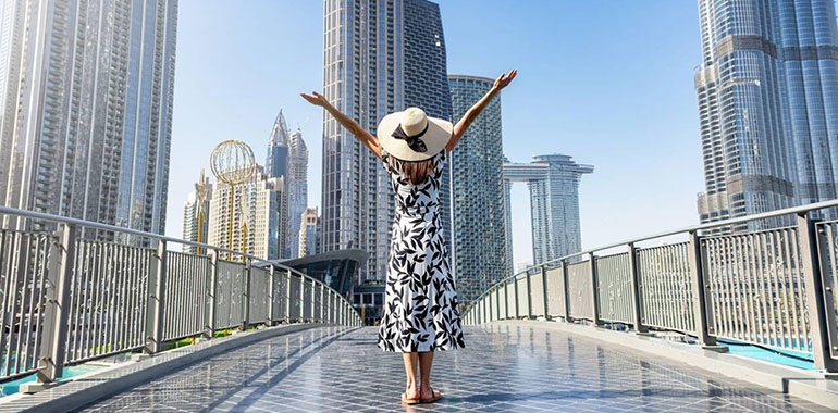 A Happy Tourist Woman In A White Dress On A Sightseeing Trip Through Downtown Dubai Uae During Her City Vacations