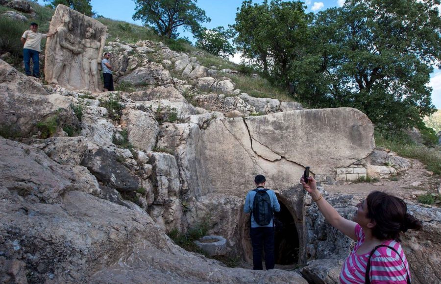A-lady-takes-a-photo-of-the-stone-carved-statue-at-Arsameia-in-eastern-Turkey-depicting-King-Antiochus-shaking-hands-with-Hercules