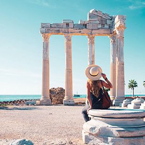 A tourist at the Temple of Apollo ancient ruins in Turkey Antalya at her 14 Days Cairo Hurghada Nile Cruise and Turkey Tour