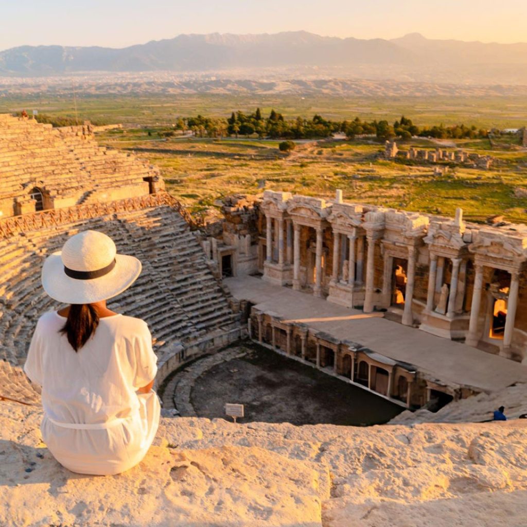 A young woman with hat watching sunset at the Hierapolis ancient city Pamukkale Turkey