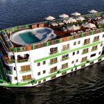 Aerial view of the MS Esmeralda Nile Cruise sailing on the river, showcasing its top sun deck, swimming pool, and multi-level guest cabins.