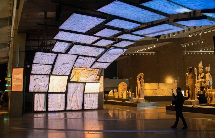 Tourists exploring the majestic halls during a Grand Egyptian Museum visit during layover