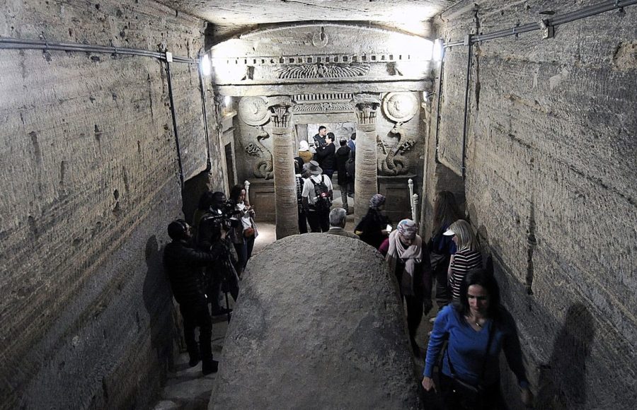 Tourists descending the spiral staircase into the famous Catacombs of Kom El Shoqafa on an Alexandria tour from Cairo